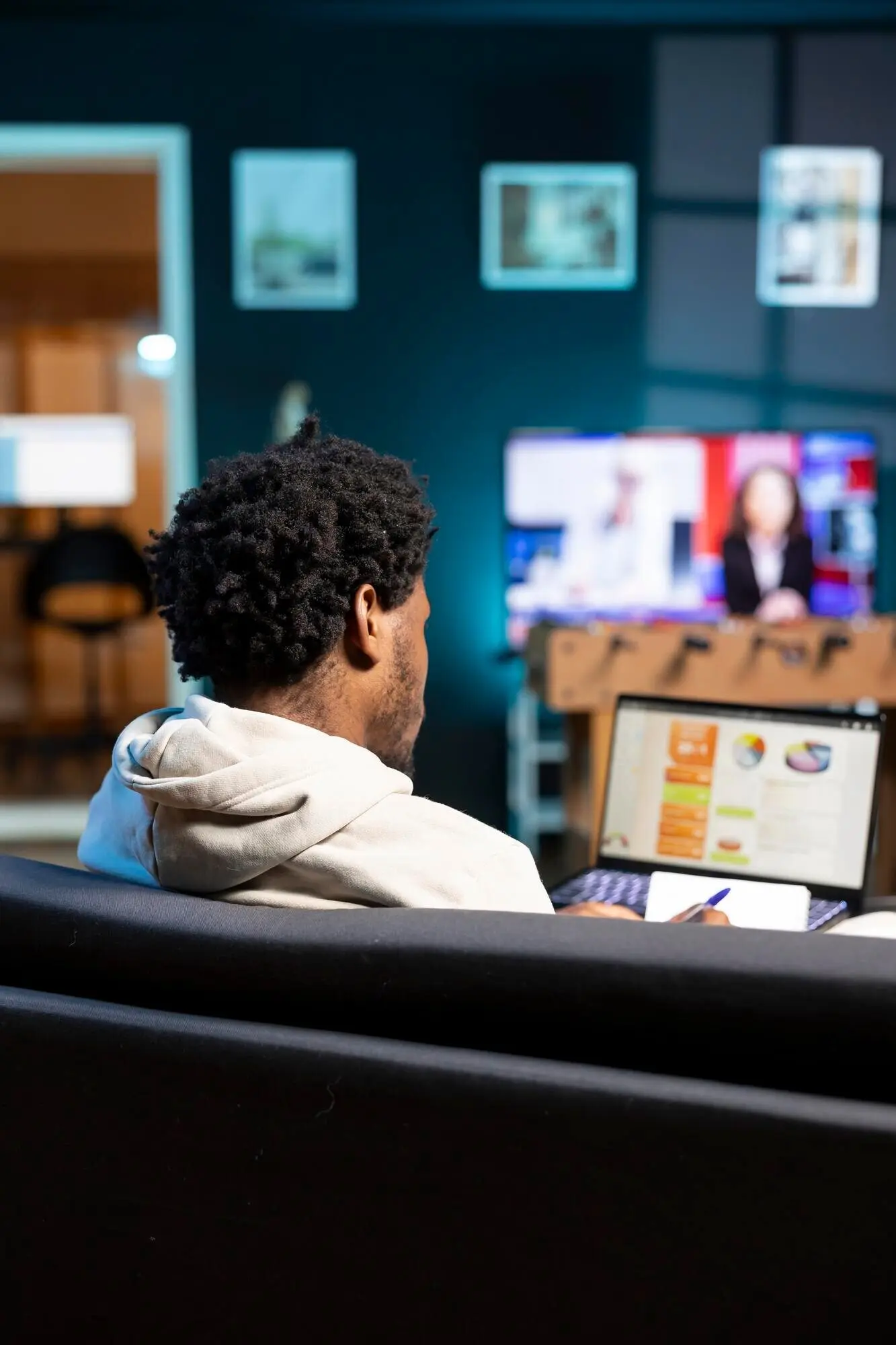 Фрилансер в гостиной квартиры сравнивает графики по бизнесу.